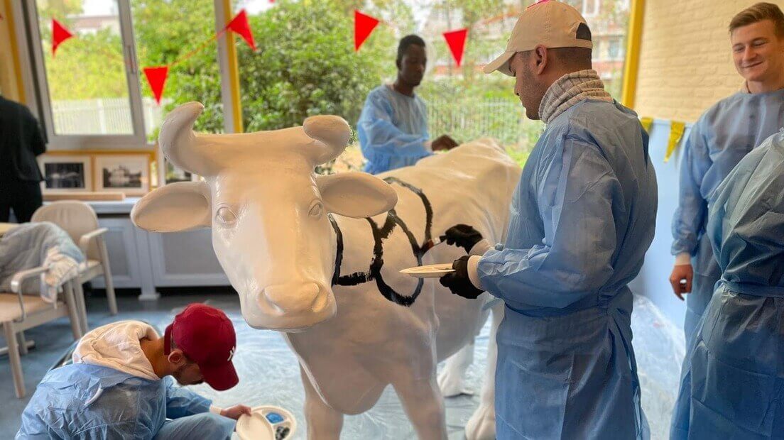 De jongeren en statushouders werken aan een kunstwerk