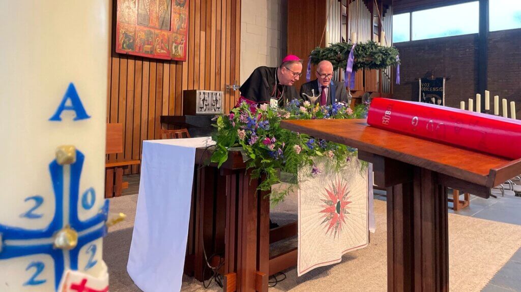 Hulpbisschop Woorts van Utrecht en Bert Staal bespreken voor de speciale mis de onthulling van het botje